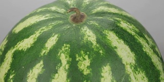 旋转一个绿色的西瓜。特写镜头。