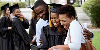 大学毕业生和父母一起看毕业照