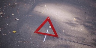两个女孩撞到了汽车的轮子，并在路上设置了紧急三角形标志