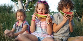 孩子们喜欢吃西瓜，并竖起大拇指。类。健康食品，暑假