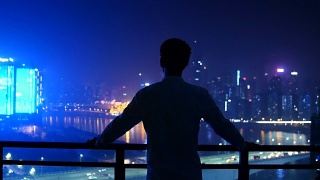 在重庆，一个年轻人看着城市的轮廓线视频素材模板下载