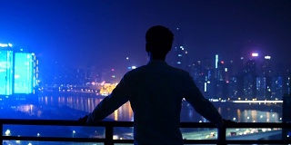 在重庆，一个年轻人看着城市的轮廓线