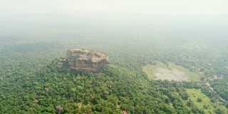 陡峭的岩层高耸在阳光下，郁郁葱葱，乡村绿色景观，斯里兰卡，西格里亚