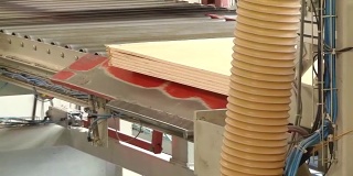 家具工厂。胶合板的生产。胶合板的自动化生产。胶合板组装阶段。这台机器切割胶合板不平整的边缘。