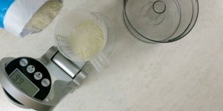 将面粉倒入量杯。用厨房秤称面粉。
