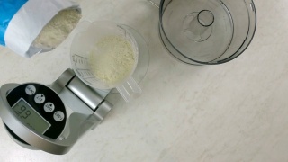 将面粉倒入量杯。用厨房秤称面粉。视频素材模板下载