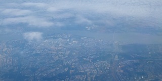 乘飞机旅行。从飞机窗口鸟瞰。空中飞过南京城市，房屋和街道。在云城。