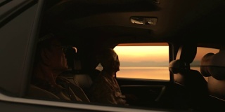 老两口在车里欣赏湖边的日落美景，慢镜头