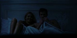 男人和女人一起看恐怖电影，坐在床上，周末休闲