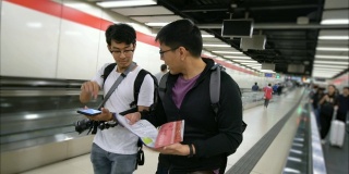两个游客朋友在谈论纸质地图和智能手机应用程序的方向
