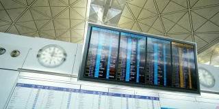 一名亚洲男子在机场盯着登机牌和智能手机