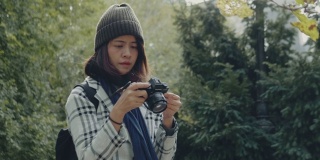 年轻的亚洲女子在中央公园用单反相机拍照。纽约