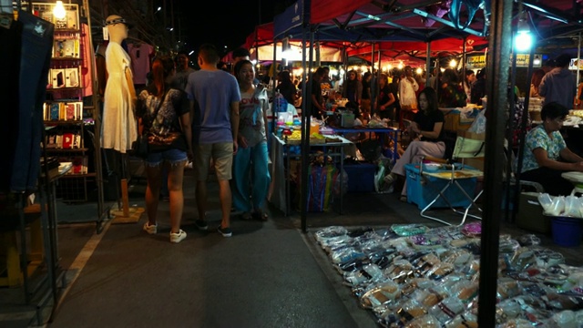 夜市夜景，身份不明的人，当地居民和游客。人们购买当地的食物和商品。