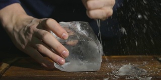酒保用特制的刀切冰块。大块的冰在FHD周围飞舞