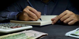 会计人员在会计帐簿上写财务数字。商业计算和家庭财务。
