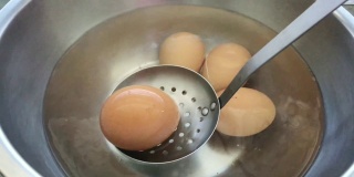 在平底锅里用热水煮鸡蛋。