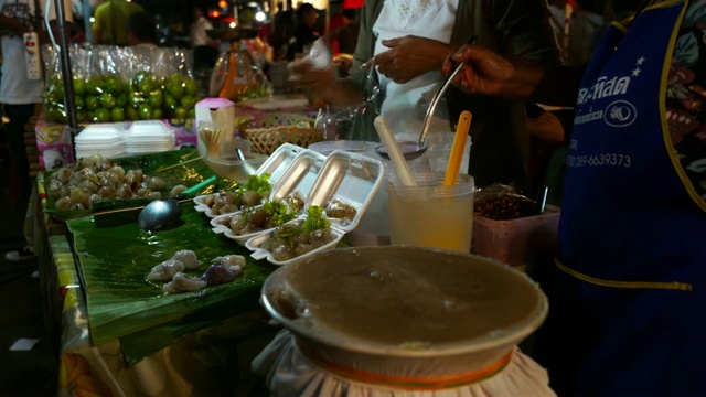 夜市夜景，身份不明的人，当地居民和游客。人们购买当地的食物和商品。