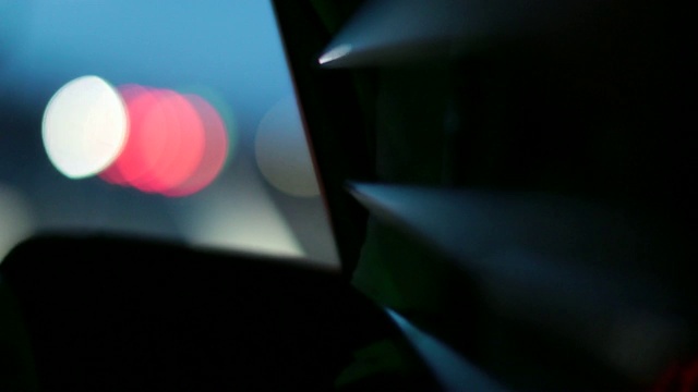 抽象的灯光散景效应在夜间驾驶的公共汽车。晚上开车时照亮金属表面