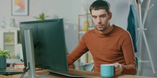 英俊自信的男人在家用个人电脑工作的肖像。在舒适明亮的客厅里，男人在浏览互联网。