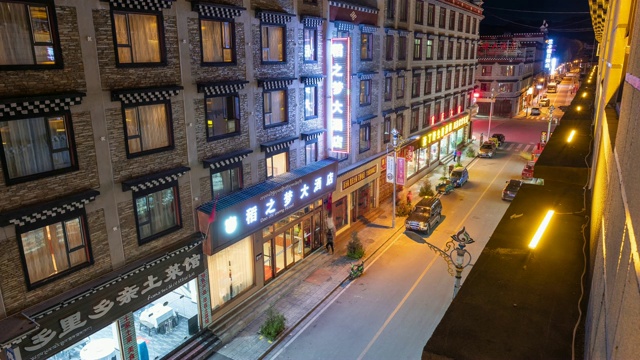 中国稻城的彩色照明城市，夜间道路上的轻车