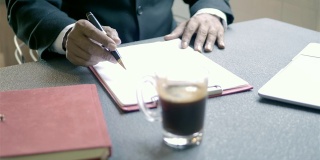 高级商人正在咖啡店里看书，签合同。
