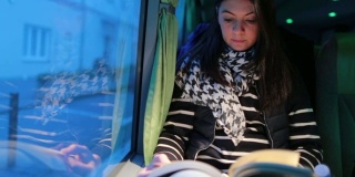 5 .一名女子在晚上旅行的公交车上看书