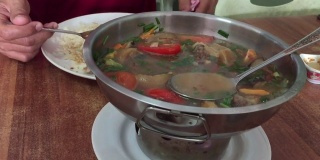特写亚洲男子吃美味的辣炖牛尾汤