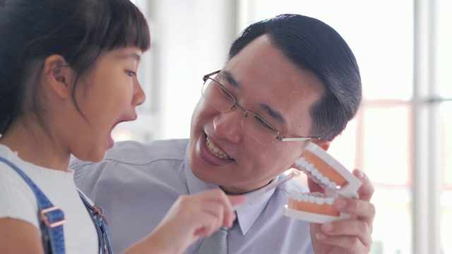 男亚裔牙医说话要好好地给女孩解释刷牙，在医院里都在听。中国和香港的医疗系统