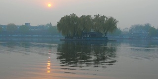 中国北京后海的日落。阳光反射在荡漾的水面上。