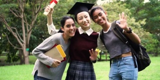 年轻的女毕业生和她的朋友们在毕业典礼上挥手。国际多元化背景