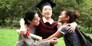 年轻的女毕业生在毕业典礼上拥抱她的朋友。国际多元化背景