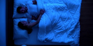 男人和女人睡在床上。晚上晚上时间