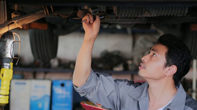 年轻的机械师在车间从事汽车服务、维修、保养和人的概念。小型企业