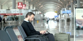 在机场候机室使用平板电脑的乘客