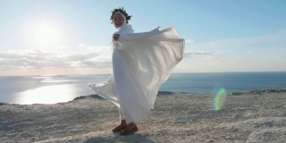 穿着白裙子的年轻女子微笑着在悬崖上打转