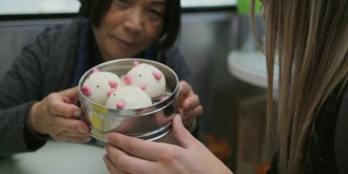在香港一家餐馆里，女游客们正在享用可爱的猪形点心
