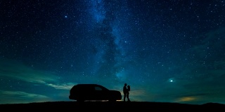 这对情侣站在一辆汽车旁，背景是星空。时间流逝