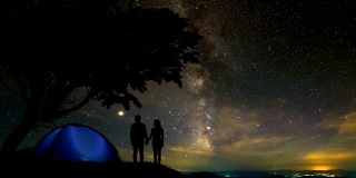 一名男子和一名女子站在流星雨背景下的一棵树旁。时间流逝