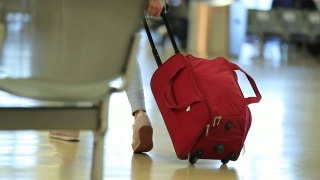 在机场携带带轮子的行李的人在4K视频素材模板下载