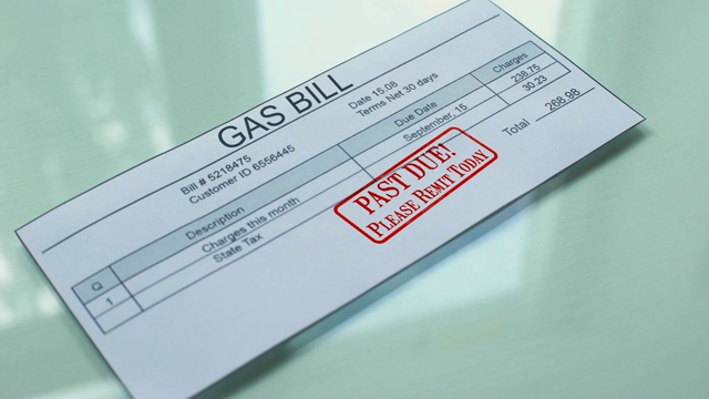 Past due gas bill, hand stamping seal on document, payment for services, tariff