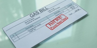 Past due gas bill, hand stamping seal on document, payment for services, tariff