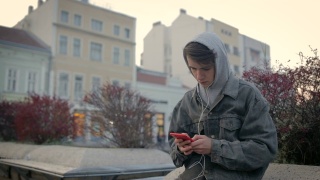 在城市环境中听音乐的少年视频素材模板下载
