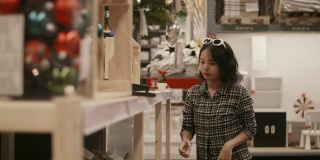 亚洲女孩购买圣诞饰品在礼品店。