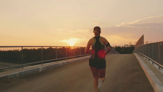 日落时分，一个女人跑过一座桥