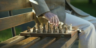 老人独自在公园里休息下棋，退休福利，特写