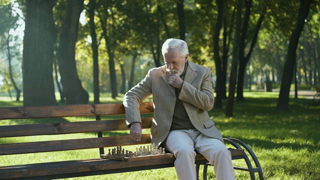 自信的老人在公园里下棋放松，晚年生活幸福