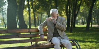 自信的老人在公园里下棋放松，晚年生活幸福