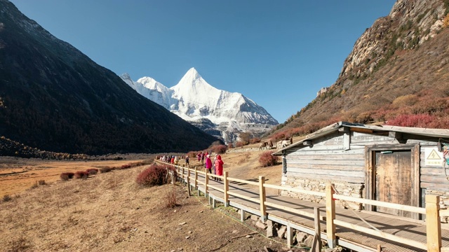 在亚丁自然保护区，西藏人和游客骑着马进入圣地羊迈永