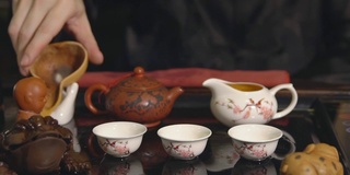 茶道。师傅将茶倒在白色杯子上