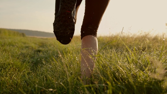 女跑步者在草地上奔跑的双腿